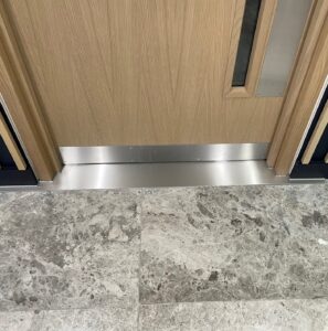 Stainless steel trim in an entrance to a lift.