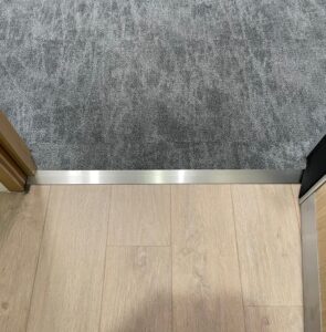 Stainless steel trim between two floor coverings